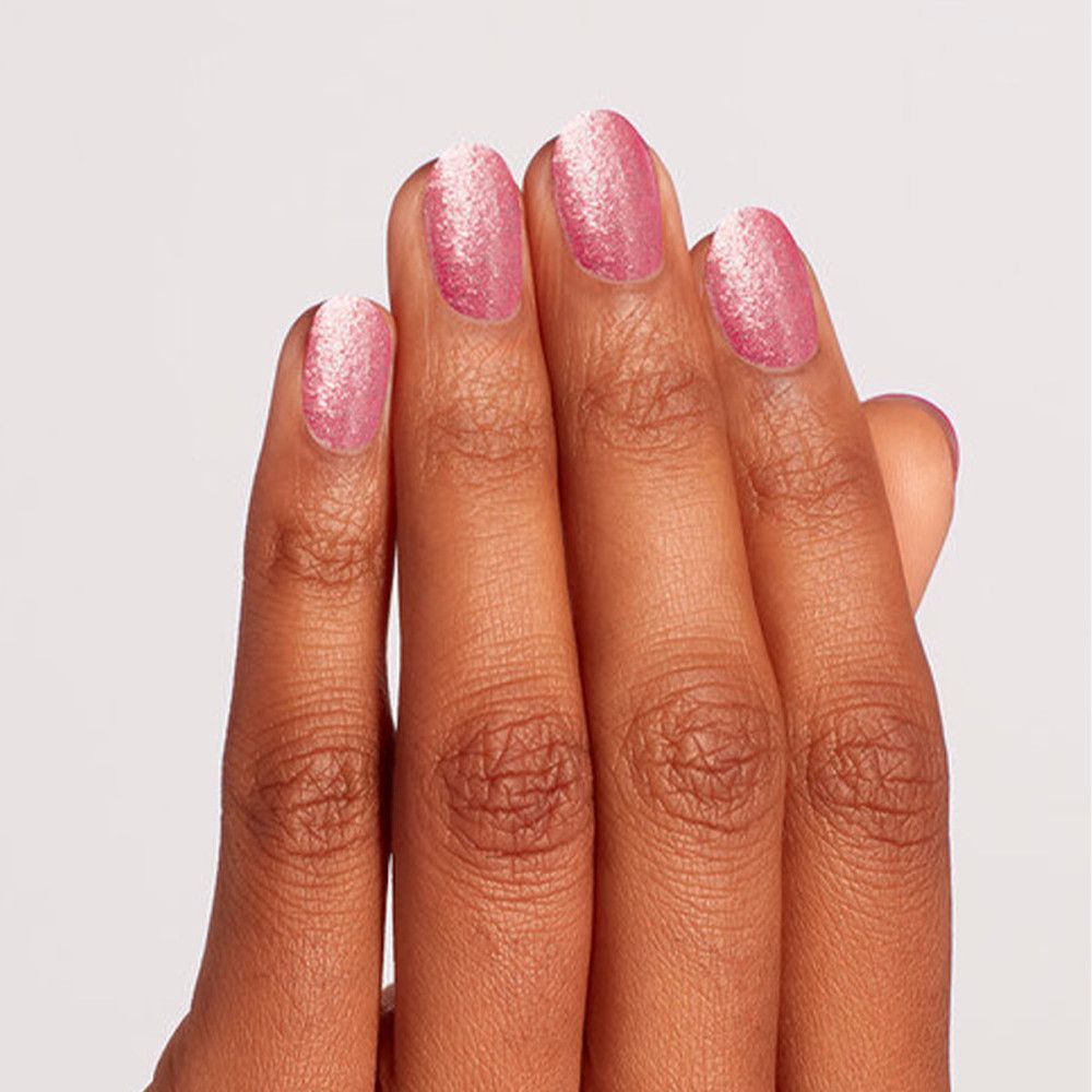 Hand mit vier Fingern, die mit rosa Glitzer-Nagellack lackiert sind.