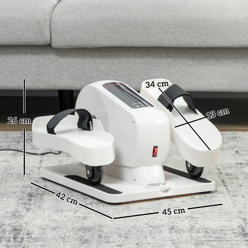 Weißes Mini-Ellipsentrainer-Fitnessgerät mit schwarzen Riemen, 45x42x26 cm. Rote Ein-/Aus-Taste, Rollen. Auf Teppich vor Sofa.