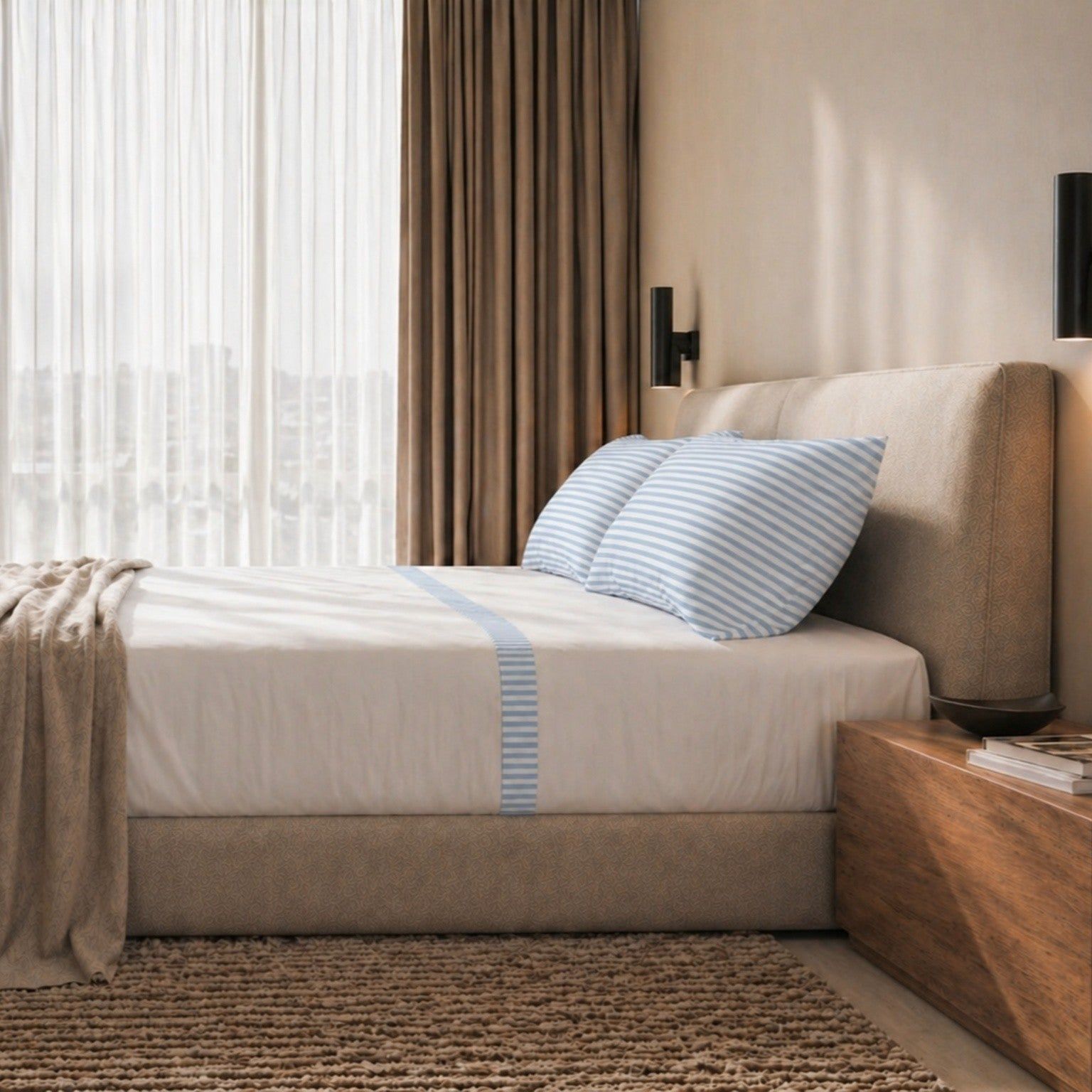 Ein gemachtes Bett mit gestreiftem Bettbezug und einem weißen Laken mit Streifen.