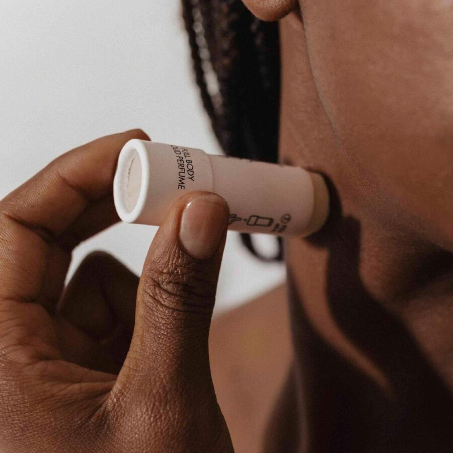 Person verwendet zylindrischen Behälter. Produkt wird auf die Haut aufgetragen. Behälter mit SLOW SEX by Bijoux Indiscrets beschriftet.