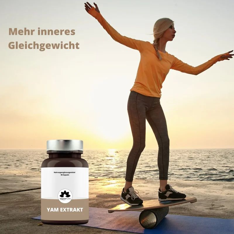 Flasche Yam Extrakt neben einer Frau im Gleichgewicht auf einem Brett am Meer.