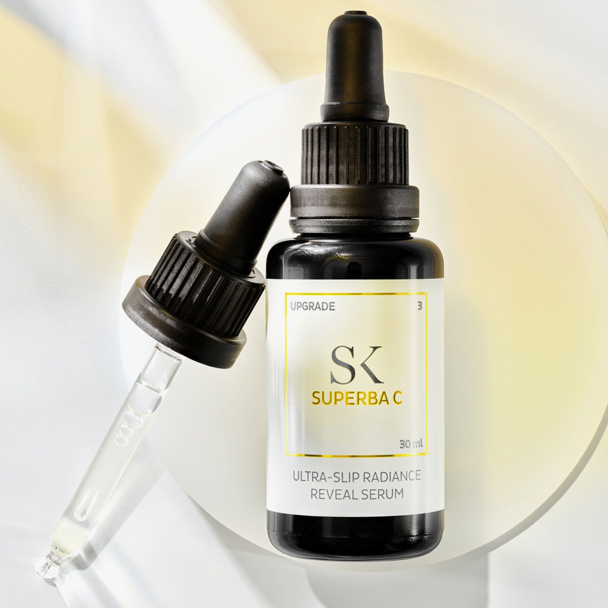 Schwarze Flasche mit Pipette und separater Pipette. Auf dem Etikett steht "SK SUPERBA C" und "ULTRA-SLIP RADIANCE REVEAL SERUM".