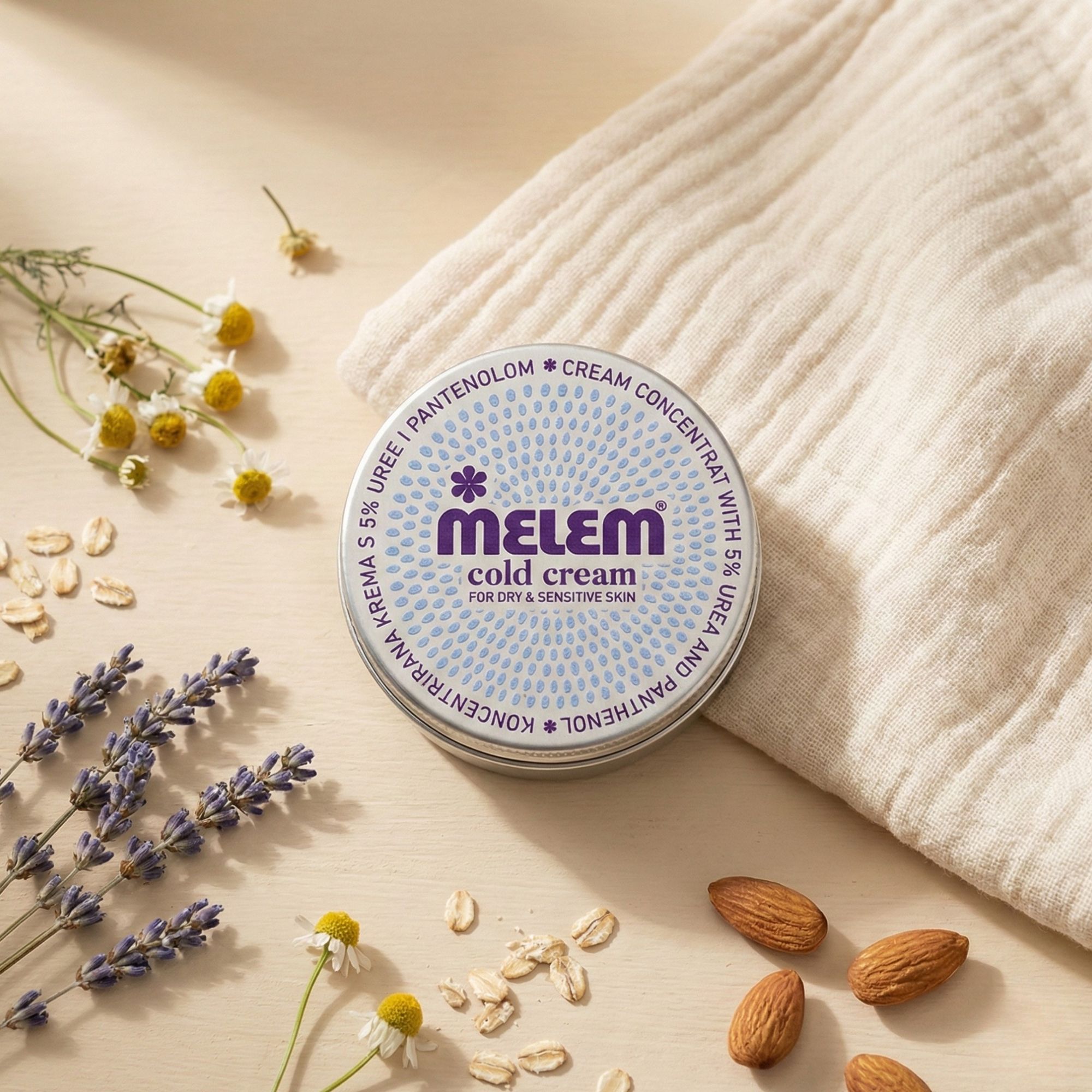 Runde Dose Melem Cold Cream, umgeben von Lavendel, Kamille, Haferflocken und Mandeln.