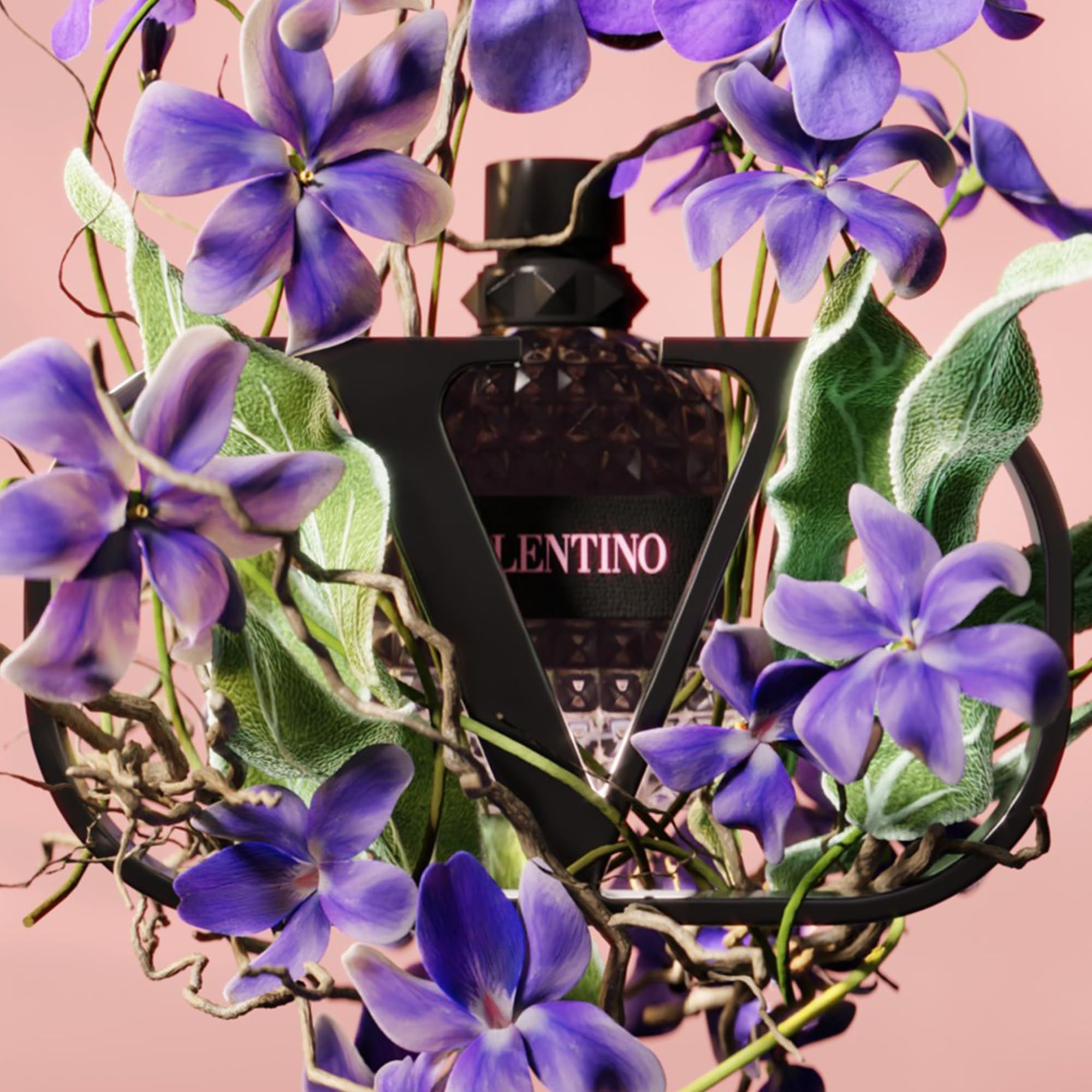 Valentino-Flakon umgeben von Blumen und Blättern. Rosa Hintergrund. Schwarzes Logo.