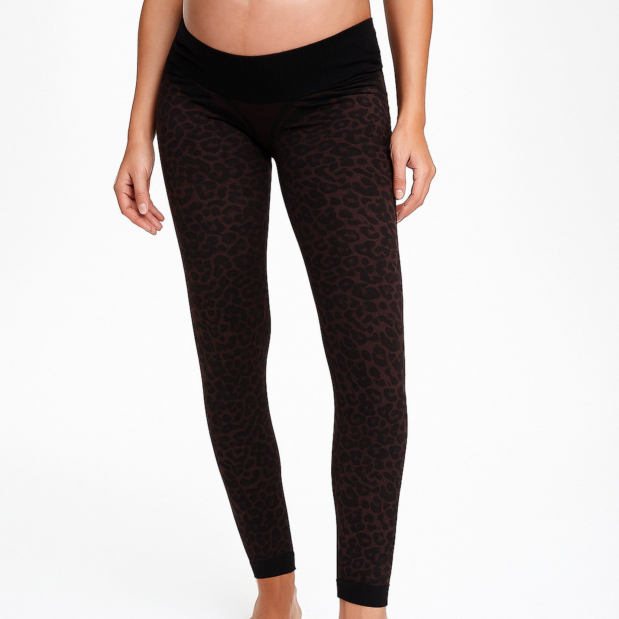 Braune Leggings mit Leopardenmuster und schwarzem Bund. Schwangere Frau.