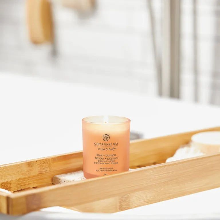 Brennende Kerze auf einem Badewannenablagebrett. Aufschrift Chesapeake Bay mind & body, love + passion.