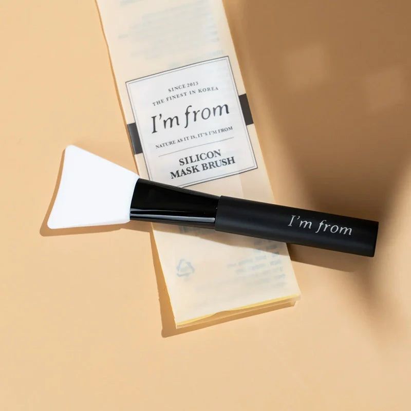 Silikonspatel und Verpackung. Schwarzer Griff mit "I'm from"-Schriftzug. Weißer Spatelkopf. Verpackung mit Logo.