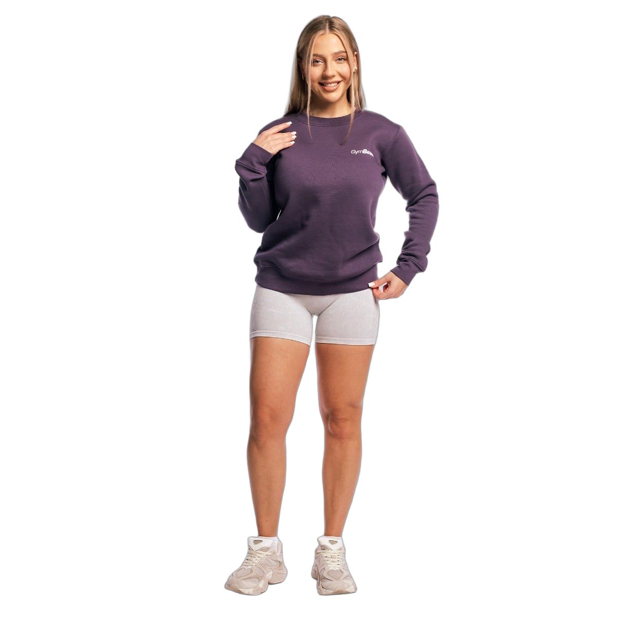 Damen Pullover in Obsidian, mit kurzer Hose und Turnschuhen.