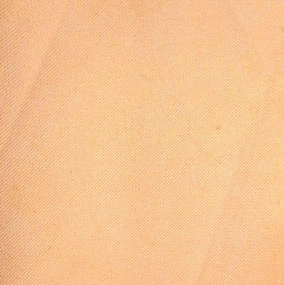 Stoffmuster in Pfirsich-Farbe. Gewebte Textur mit diagonalem Muster. Nahaufnahme.