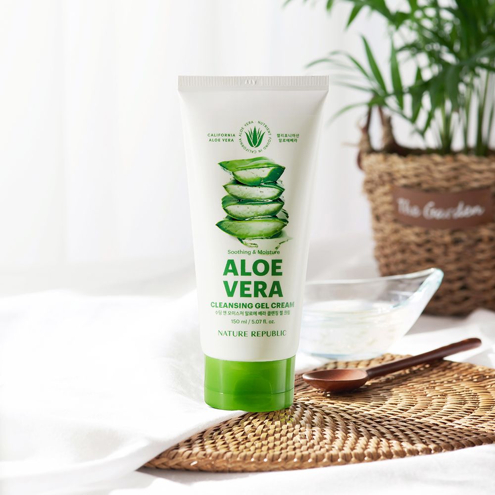 Produkt auf Tisch mit Pflanzen im Hintergrund. Weiß-grüne Tube mit Aloe Vera-Abbildung und Schriftzug. Marke: NATURE REPUBLIC.