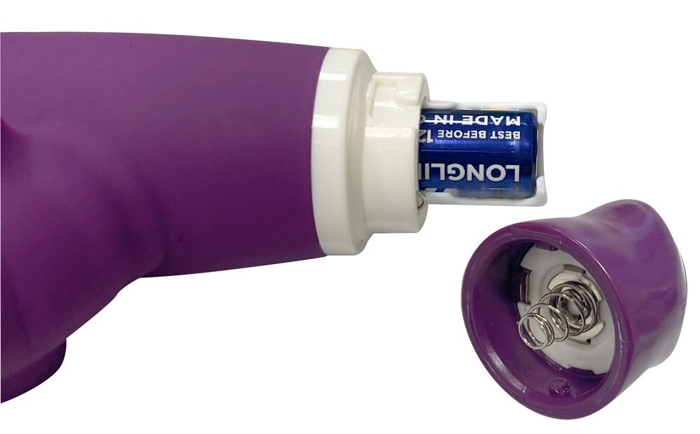 Nahaufnahme eines lila Vibrators. Batteriefach geöffnet, Batterien sichtbar. Auf weißem Hintergrund.