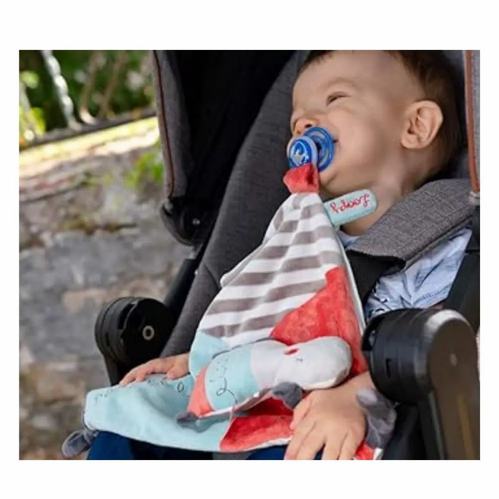 Kind im Kinderwagen mit Kuscheltuch und Schnuller. Gestreiftes Tuch, Nilpferd-Kopf.