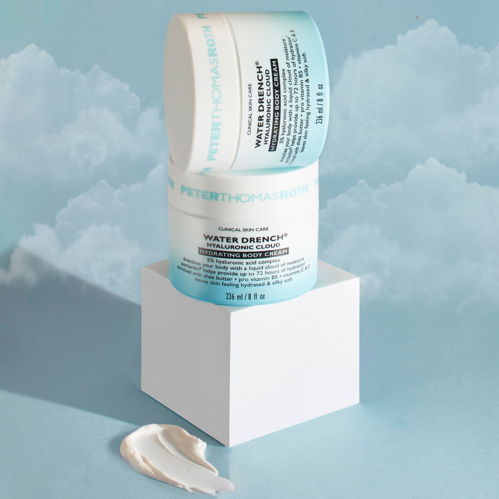 Zwei Cremebehälter gestapelt. Aufschrift: Water Drench Hyaluronic Cloud Hydrating Body Cream. Hintergrund: weißer Sockel, Creme.