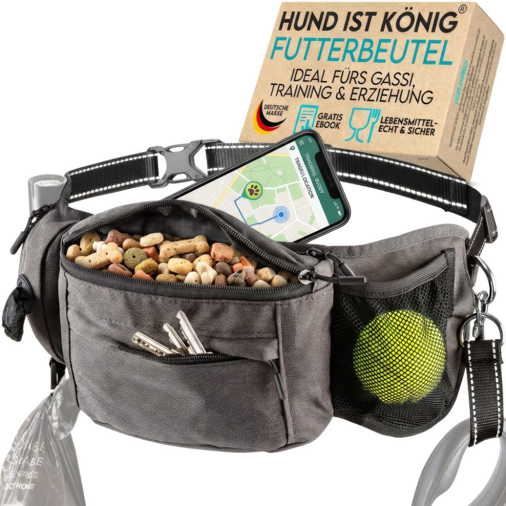 Graue Bauchtasche mit Futter, Handy, Schlüssel, Ball und Kotbeutel. Schwarzer Gurt mit Schnalle. Text: HUND IST KÖNIG® Futterbeutel.