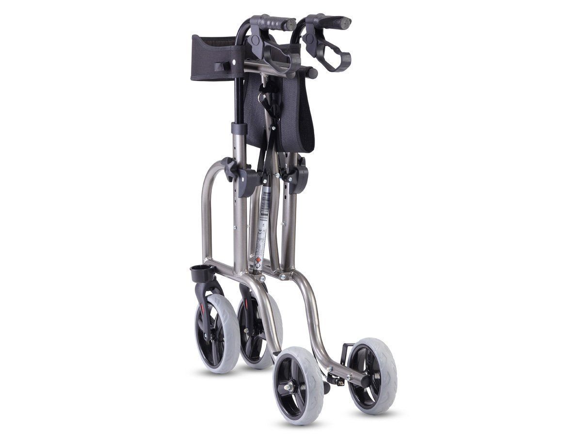 Zusammengeklappter Rollator. Vier Räder, silberner Rahmen, schwarze Sitzfläche und Rückenlehne. Kompakte Form.