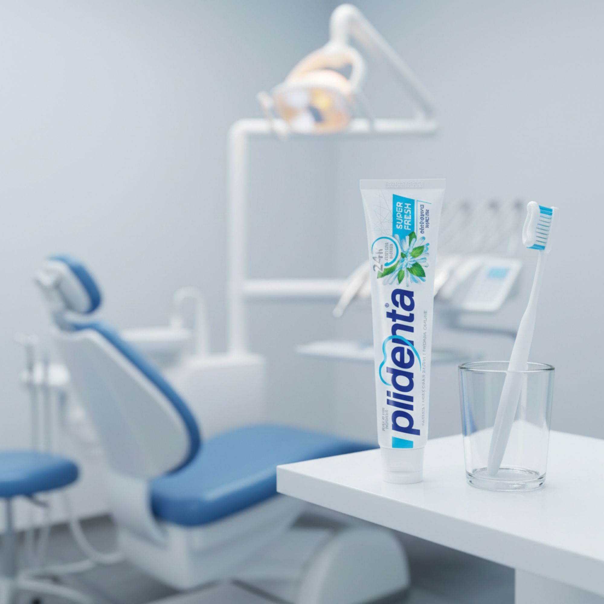 Zahnpasta-Tube, Glas und Zahnbürste in einem Zahnarztzimmer. Aufschrift: Super Fresh. Blaue und weiße Farbgebung.