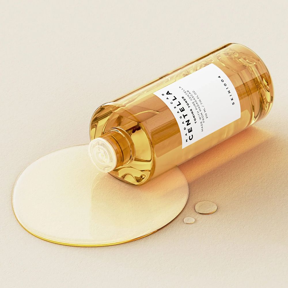 Toner-Flasche liegt. Flüssigkeit auf Oberfläche. Produktname und Marke sichtbar.
