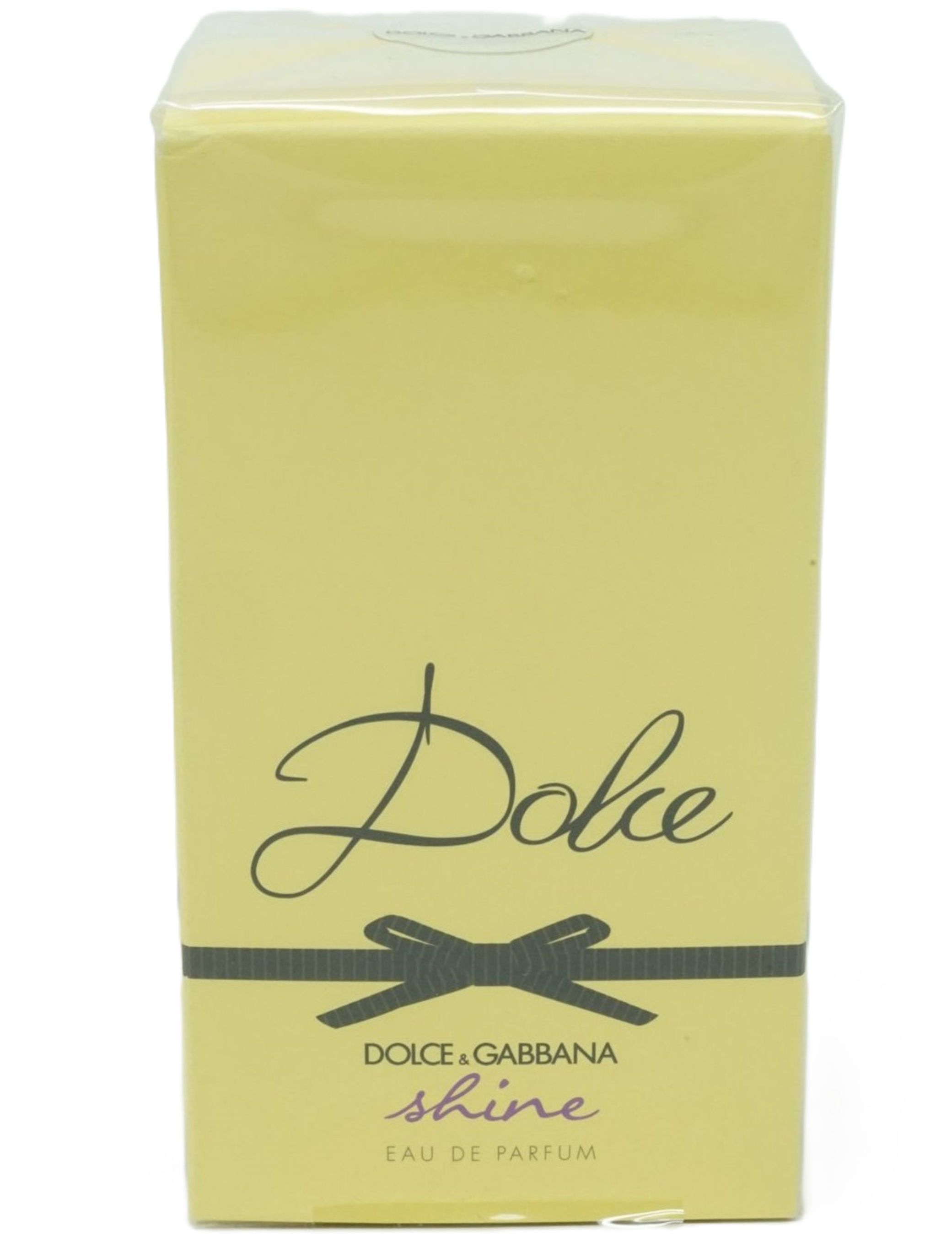 Gelbe Parfümverpackung mit Aufschrift "Dolce", schwarzer Schleife und "shine".