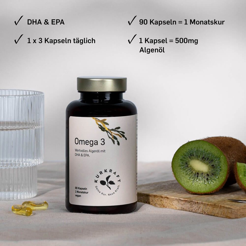 Flasche Omega 3 Algenöl neben einem Glas Wasser, Kiwischeiben und Kapseln auf einem Tisch.