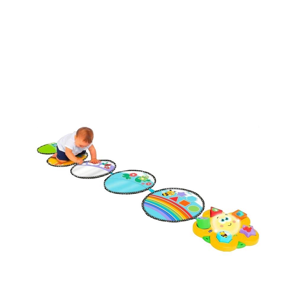 Sensorischer Teppich mit fünf ovalen Elementen. Baby krabbelt über die Elemente. Verschiedene Farben und Muster.
