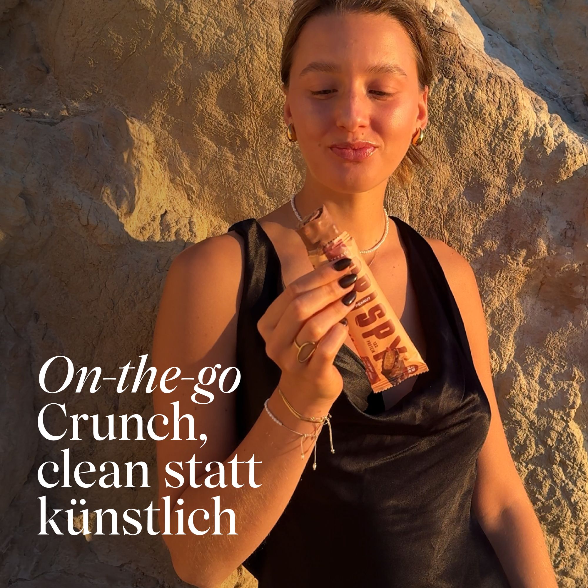 Junge Frau hält einen VETAIN Proteinriegel Crispy Peanut.