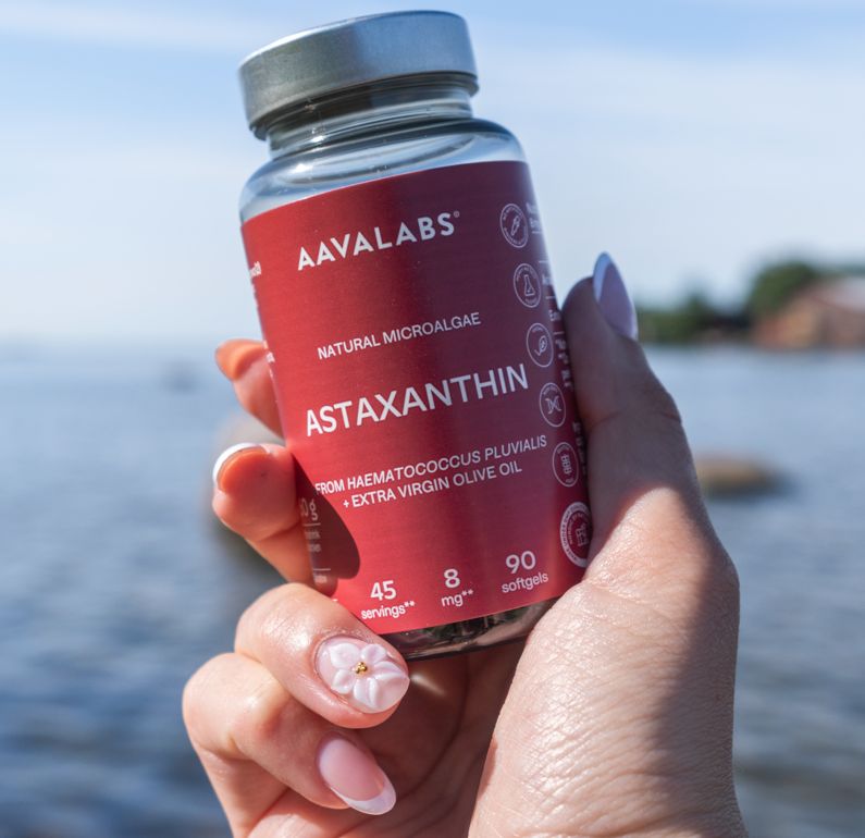 Hand hält eine Flasche Aavalabs Astaxanthin 8 mg vor dem Wasser.