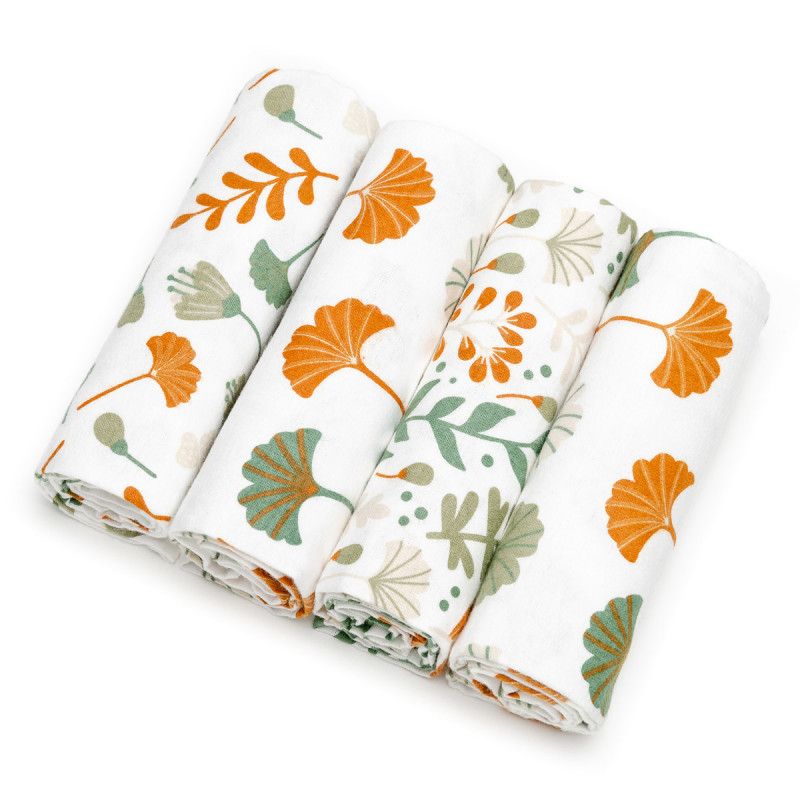 Vier gerollte Stoffwindeln mit Ginkgo-Blatt-Muster in Orange und Grün auf weißem Grund.