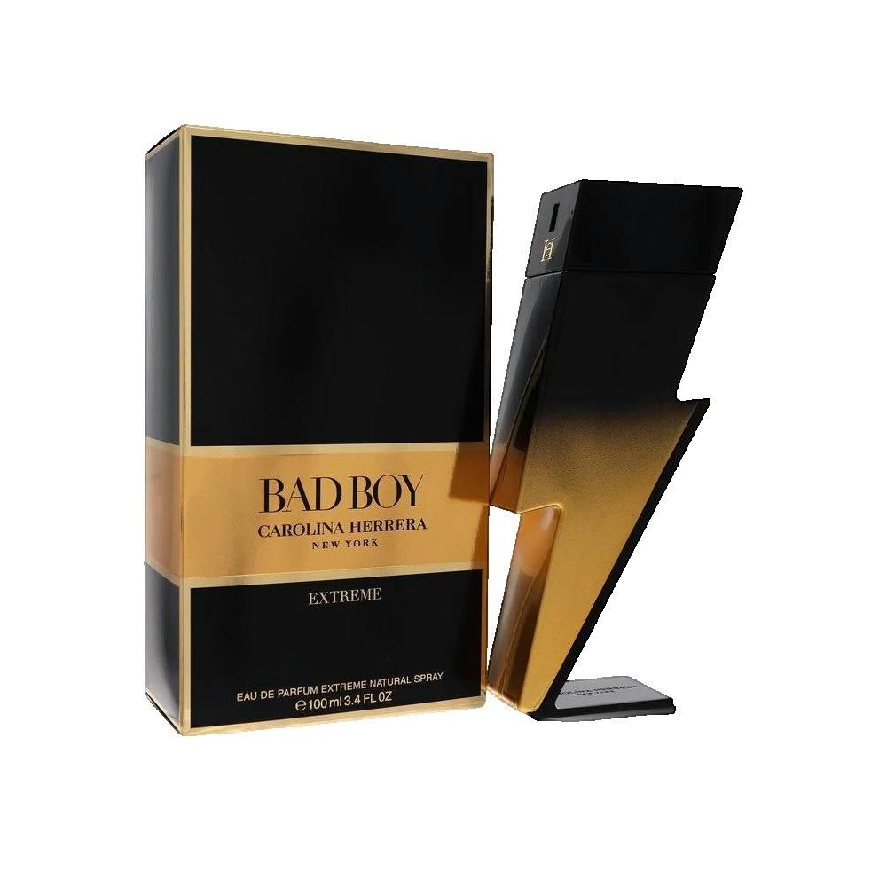 Schwarzer Karton mit goldfarbenem Streifen. Flakon in Blitzform daneben. Text: BAD BOY, CAROLINA HERRERA, EXTREME.