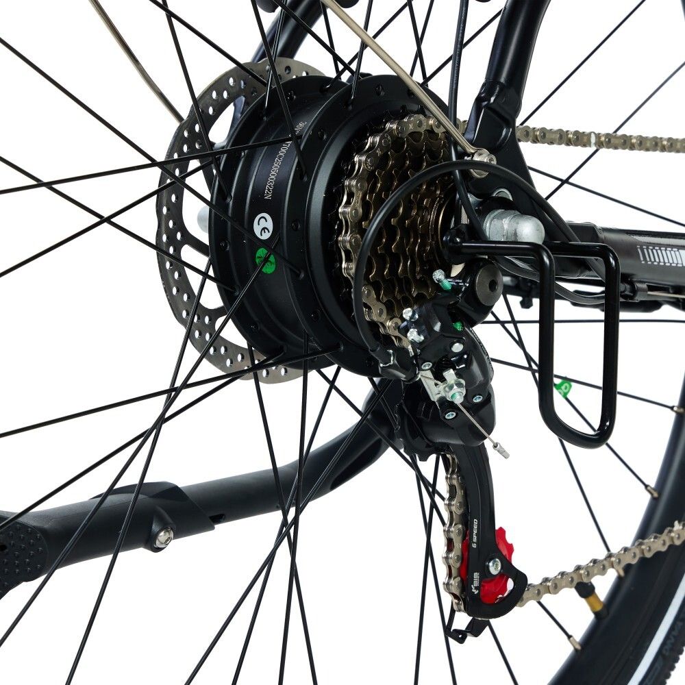 Nahaufnahme des Hinterrads eines Elektrofahrrads. Sichtbar sind Zahnräder, Bremsscheibe, Kette und Gepäckträger.