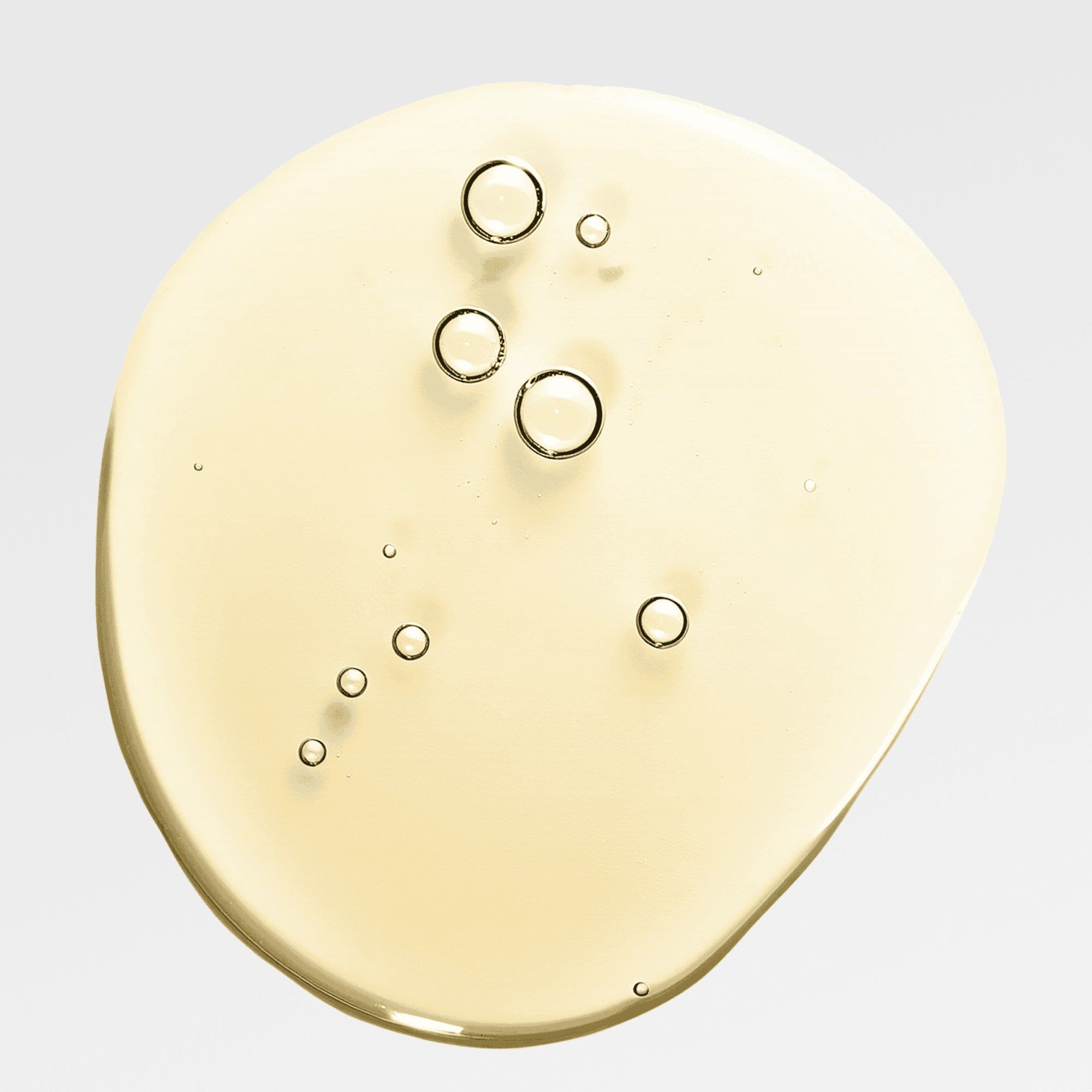 Gelbliche Flüssigkeit mit Blasen auf hellem Hintergrund. Ölreiniger-Textur.