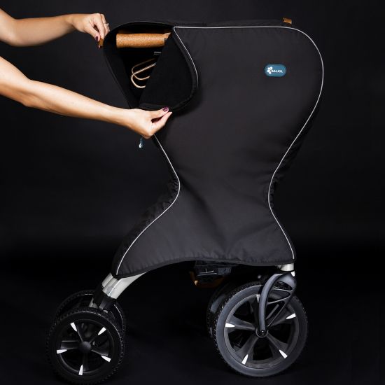 Schwarze Tasche mit weißer Kontur, teilweise geöffnet. Der Rollator ist teilweise sichtbar. Schwarzer Hintergrund.