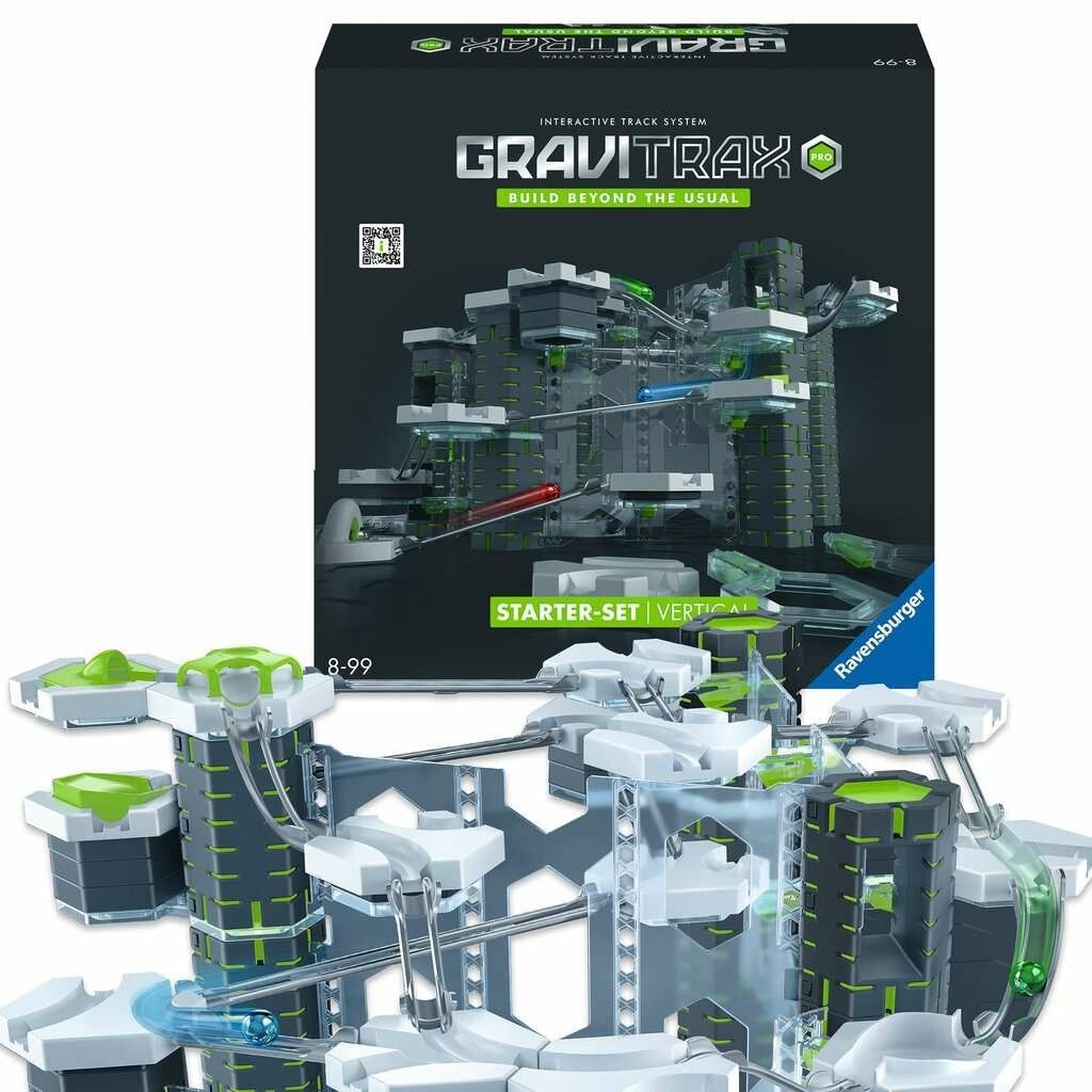GraviTrax PRO Starter-Set Vertical mit aufgebauter Bahn. Verpackung im Hintergrund. Graue, grüne und transparente Bauelemente. Kugeln.
