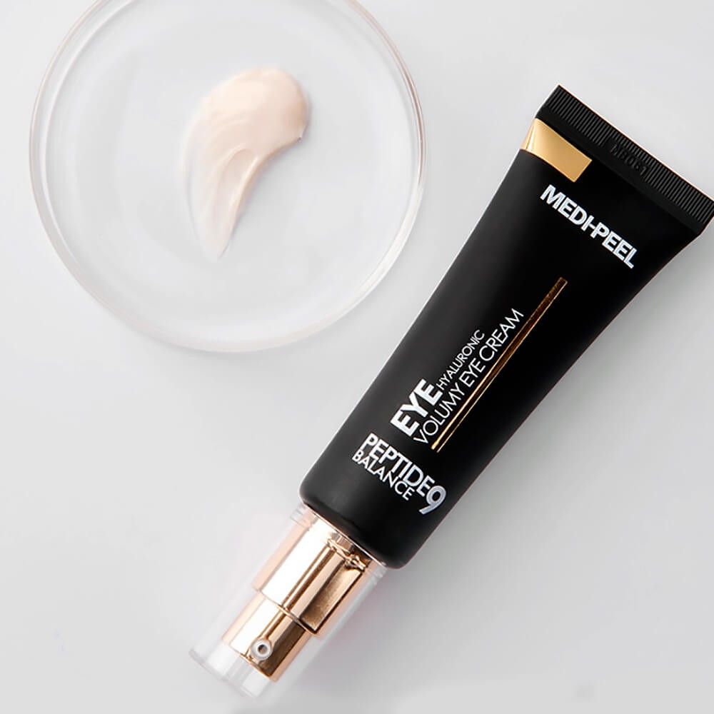 Schwarze Tube mit goldener Kappe und eine Probe der Creme daneben. Aufschrift: MEDI-PEEL PEPTIDE 9 HYALURONIC VOLUMY EYE CREAM.