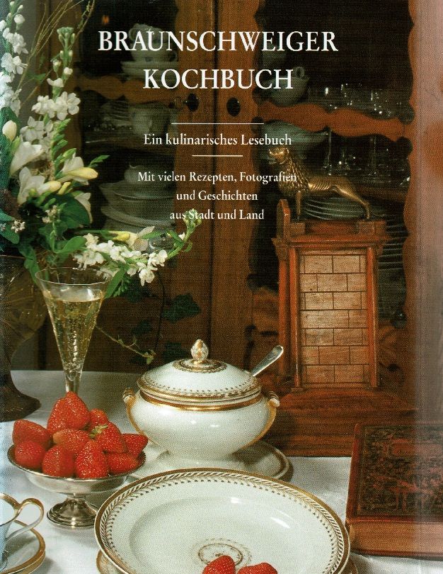 Buchcover mit Titel "Braunschweiger Kochbuch". Text: "Ein kulinarisches Lesebuch". Dekorative Elemente: Blumen, Früchte, Geschirr.