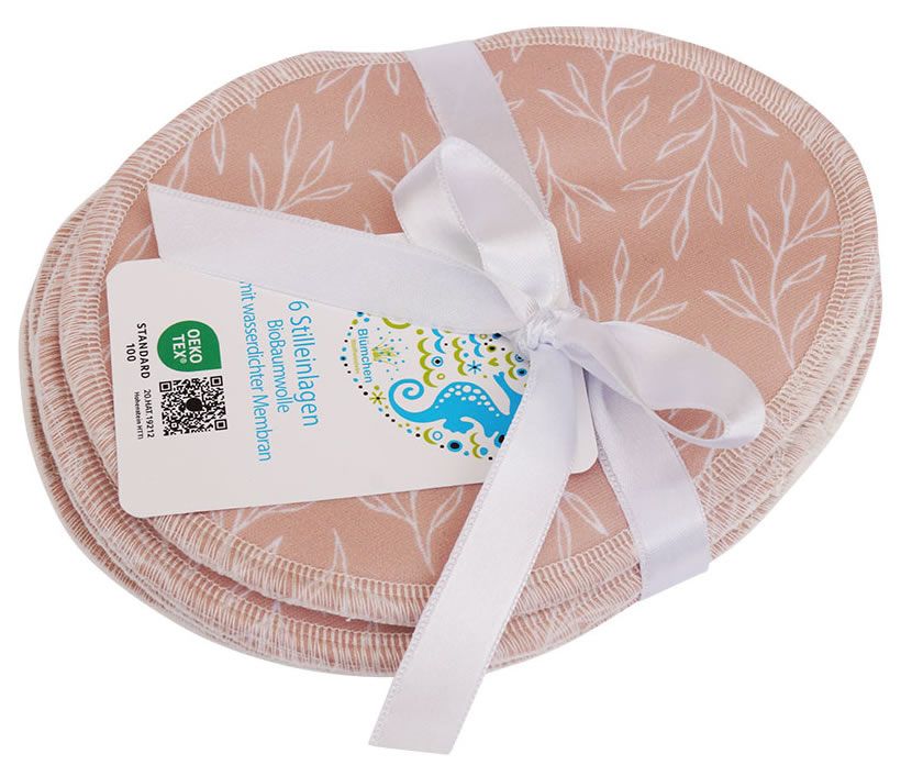 Stilleinlagen, rosa mit floralem Muster, gebunden mit weißem Band. Etikett mit Text und Logo.