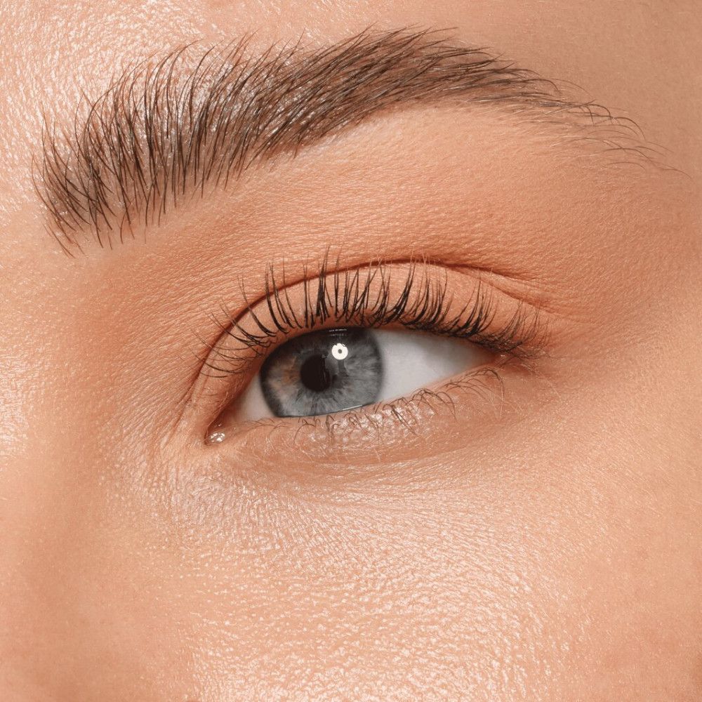 Nahaufnahme eines Auges mit Wimperntusche. Die Haut ist hell und glatt. Das Auge ist blau.