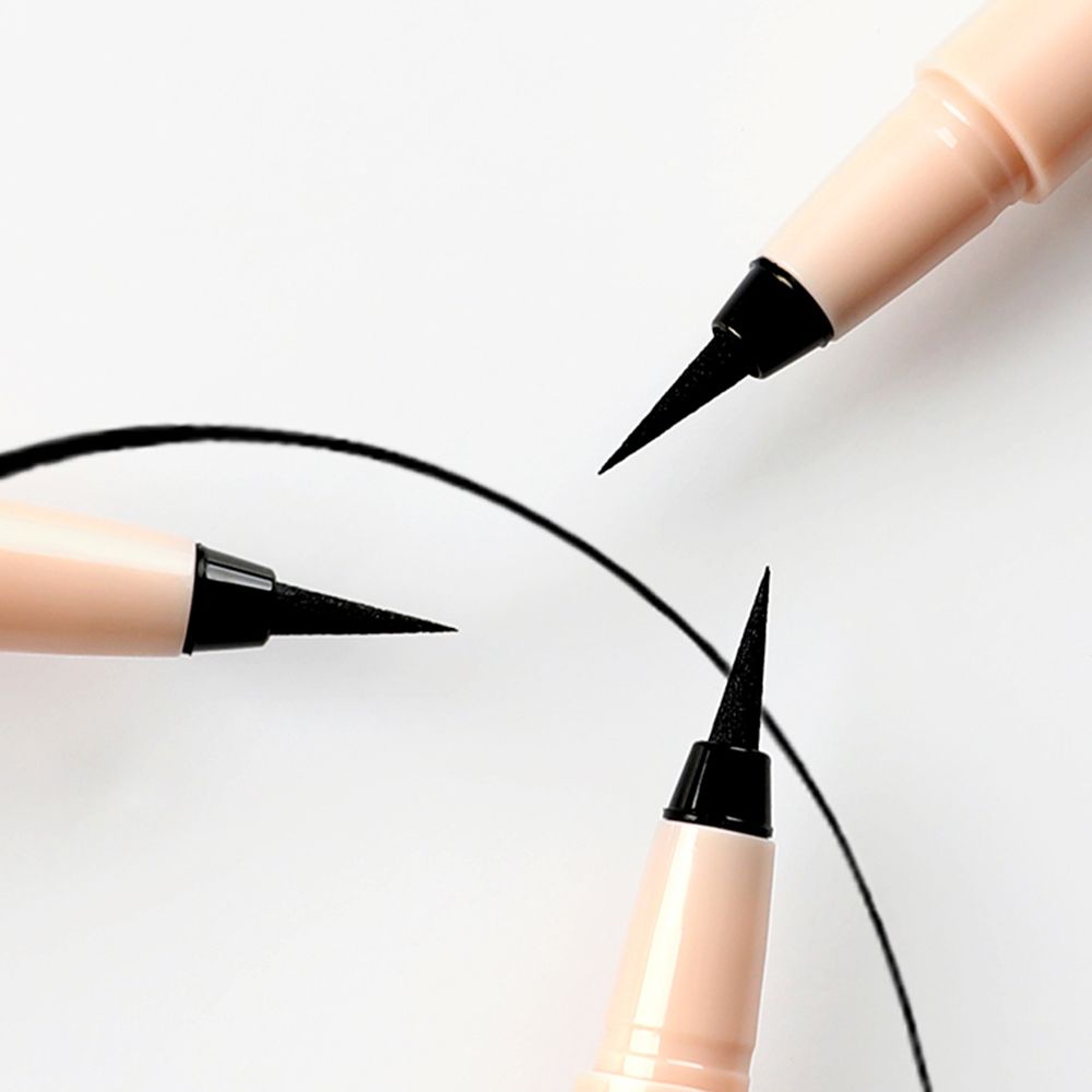 Drei Eyeliner-Stifte mit schwarzen Spitzen, die Linien auf weißem Hintergrund zeichnen.