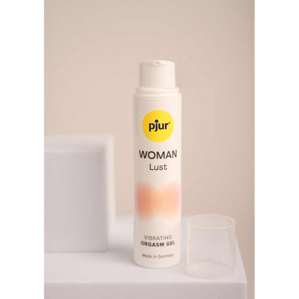 Weiße Flasche mit gelbem Logo und Produktnamen. Text: WOMAN Lust, Vibrating Orgasm Gel. Transparenter Deckel. Auf weißem Untergrund.