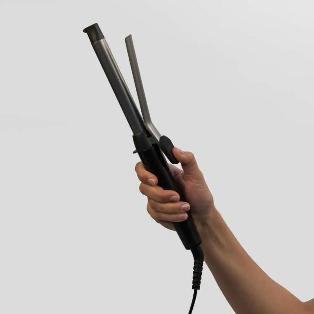 Hand hält Lockenstab. Schwarz-silberfarben. Mit Kabel.