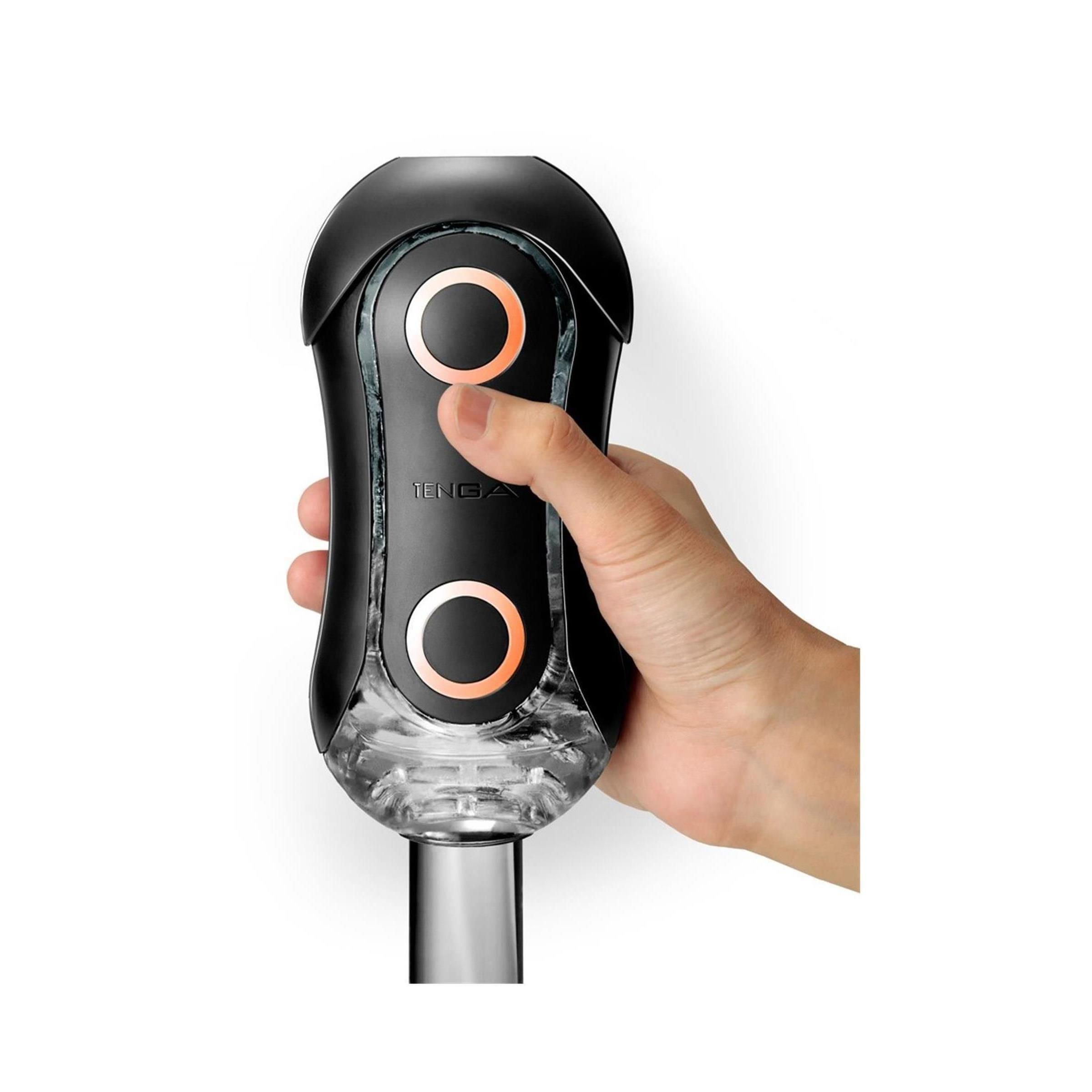 Schwarzes Wellness-Produkt mit zwei orangefarbenen Kreisen. Hand hält das Produkt. Der Markenname TENGA ist sichtbar.