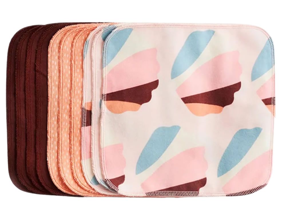 Mehrere Waschlappen, verschiedene Farben und Muster. Einige sind einfarbig, andere haben ein Muster aus bunten Formen.