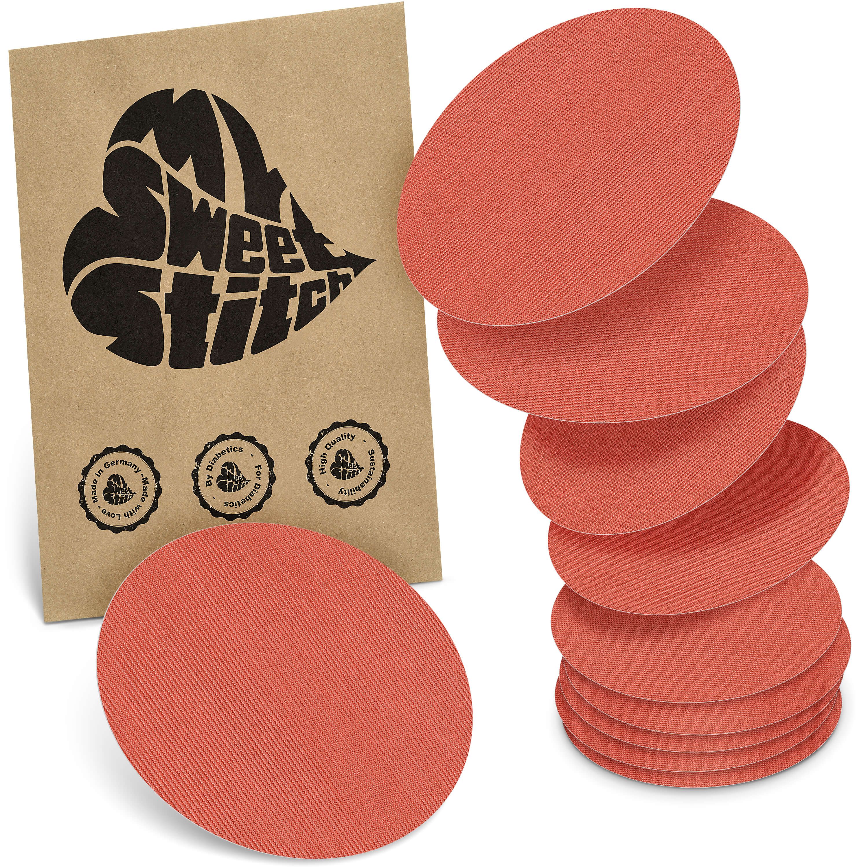 Runde, korallenfarbene Pflaster. Eine Packung mit Logo und Siegeln. Mehrere Pflaster sind gestapelt.