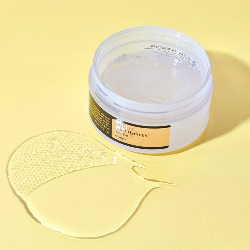 Ein Hydrogel-Augenpflaster und ein Klecks Gel auf gelbem Hintergrund.
