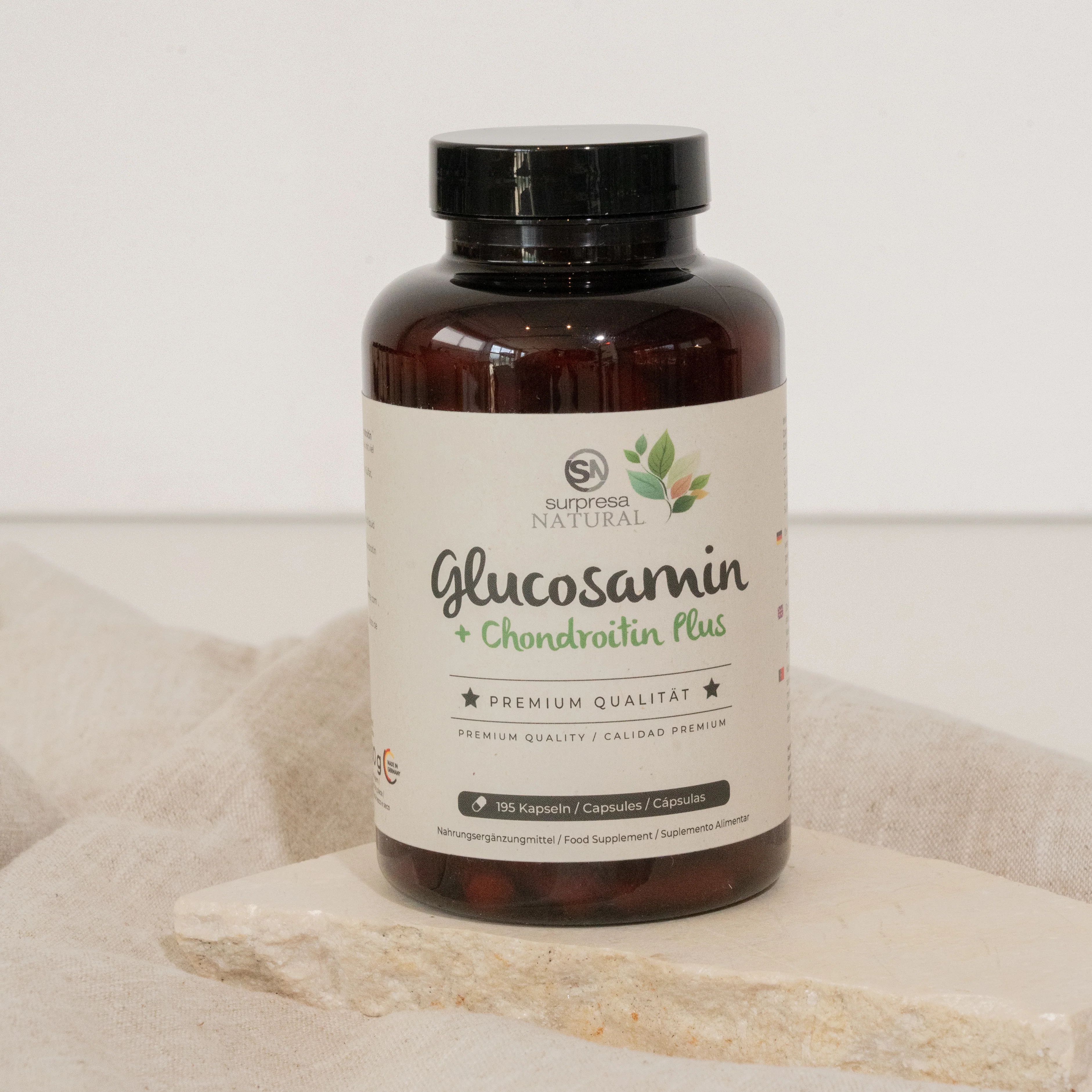 Braune Flasche mit schwarzen Deckel. Aufschrift: Glucosamin + Chondroitin Plus. Premium Qualität. Auf Stein platziert.