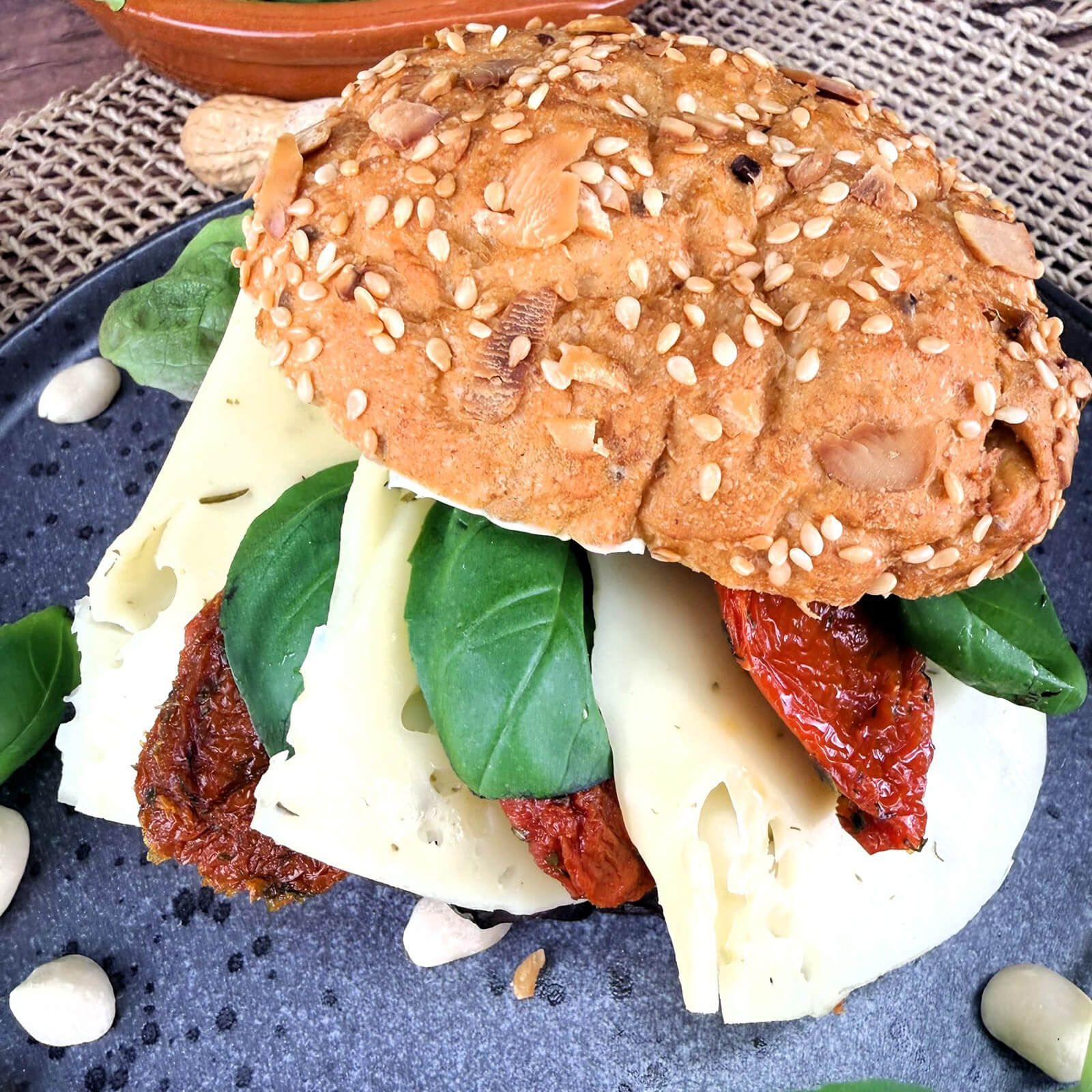 Locawo Erdmännchen Sandwich mit Käse, getrockneten Tomaten und Basilikum, Nahaufnahme.