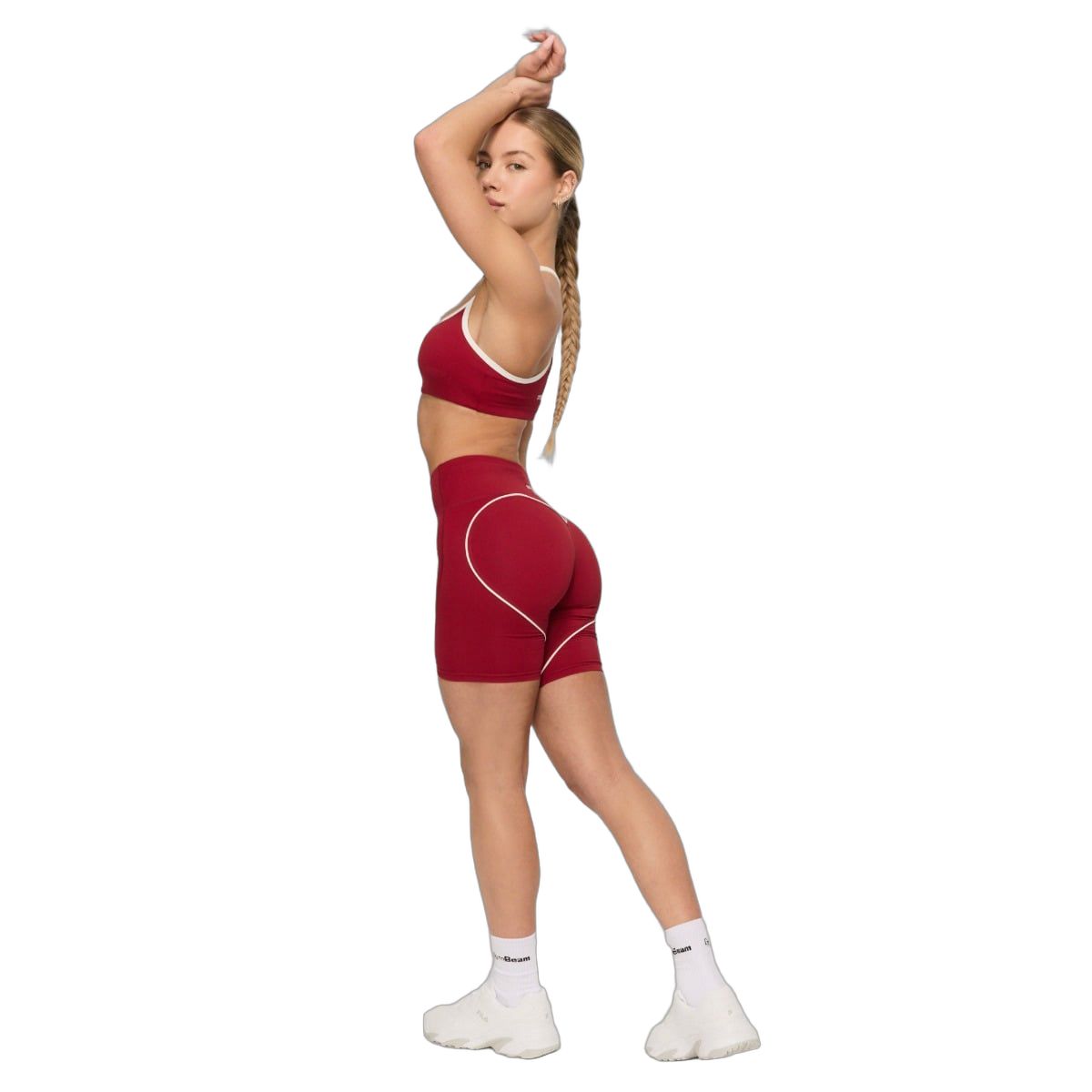 Frau in roten Sport-Shorts mit weißer Herz-Applikation und passendem Sport-BH.