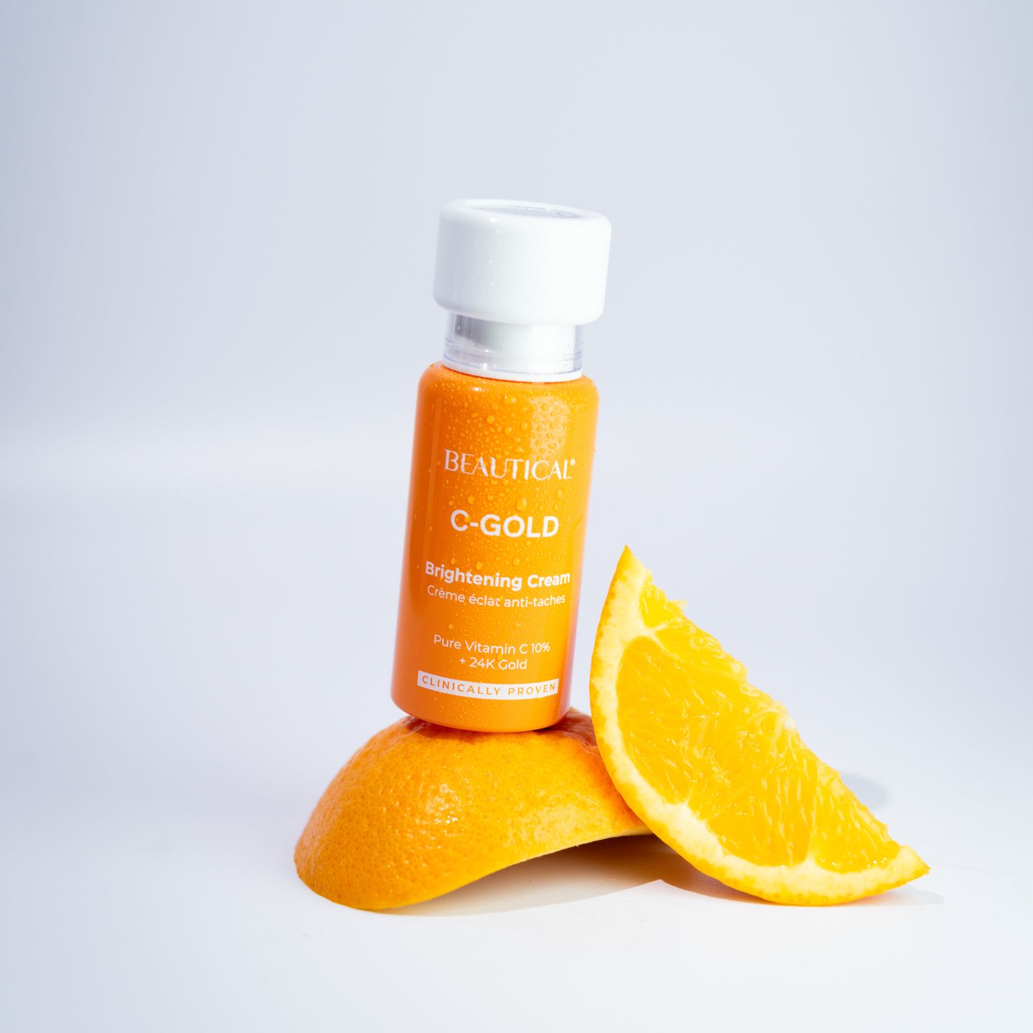 Produktflasche und Orangenscheibe. Aufschrift: BEAUTICAL C-GOLD Brightening Cream.
