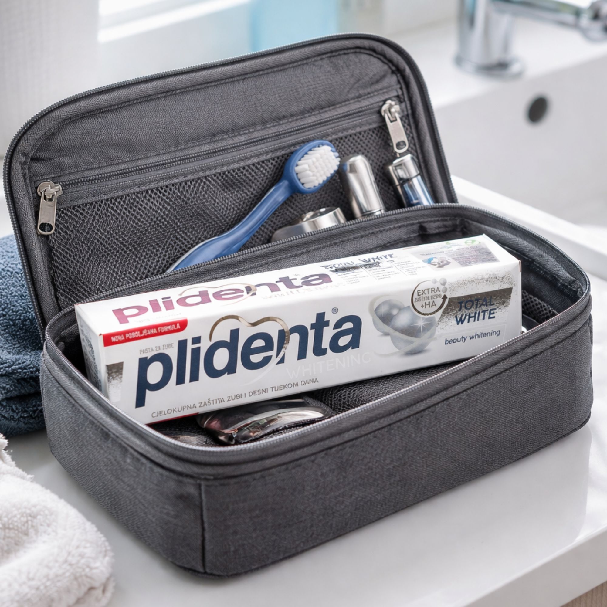 Zahnpasta in Kosmetiktasche. Produktname: Plidenta Total White. Zusätzliche Zahnbürste und Zubehör.