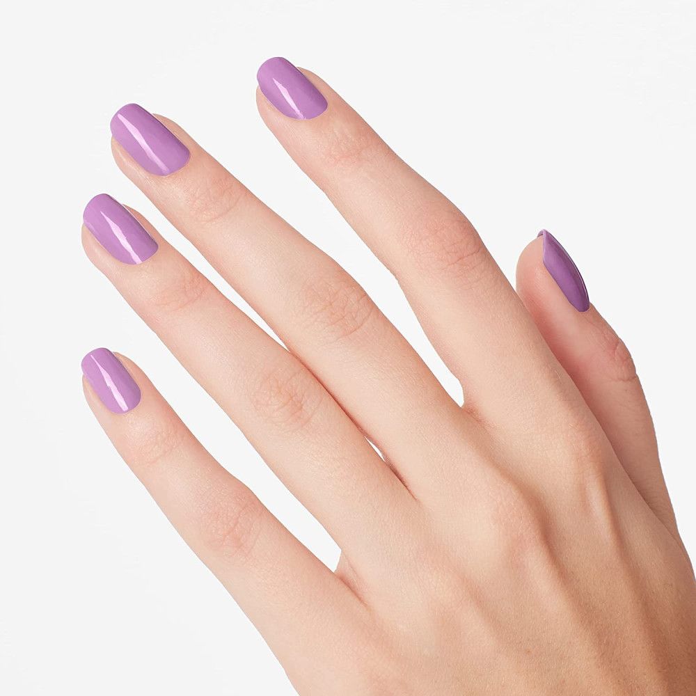 Hand mit lackierten Nägeln in Lila. Fünf Finger mit gleichmäßig lackierten Nägeln.