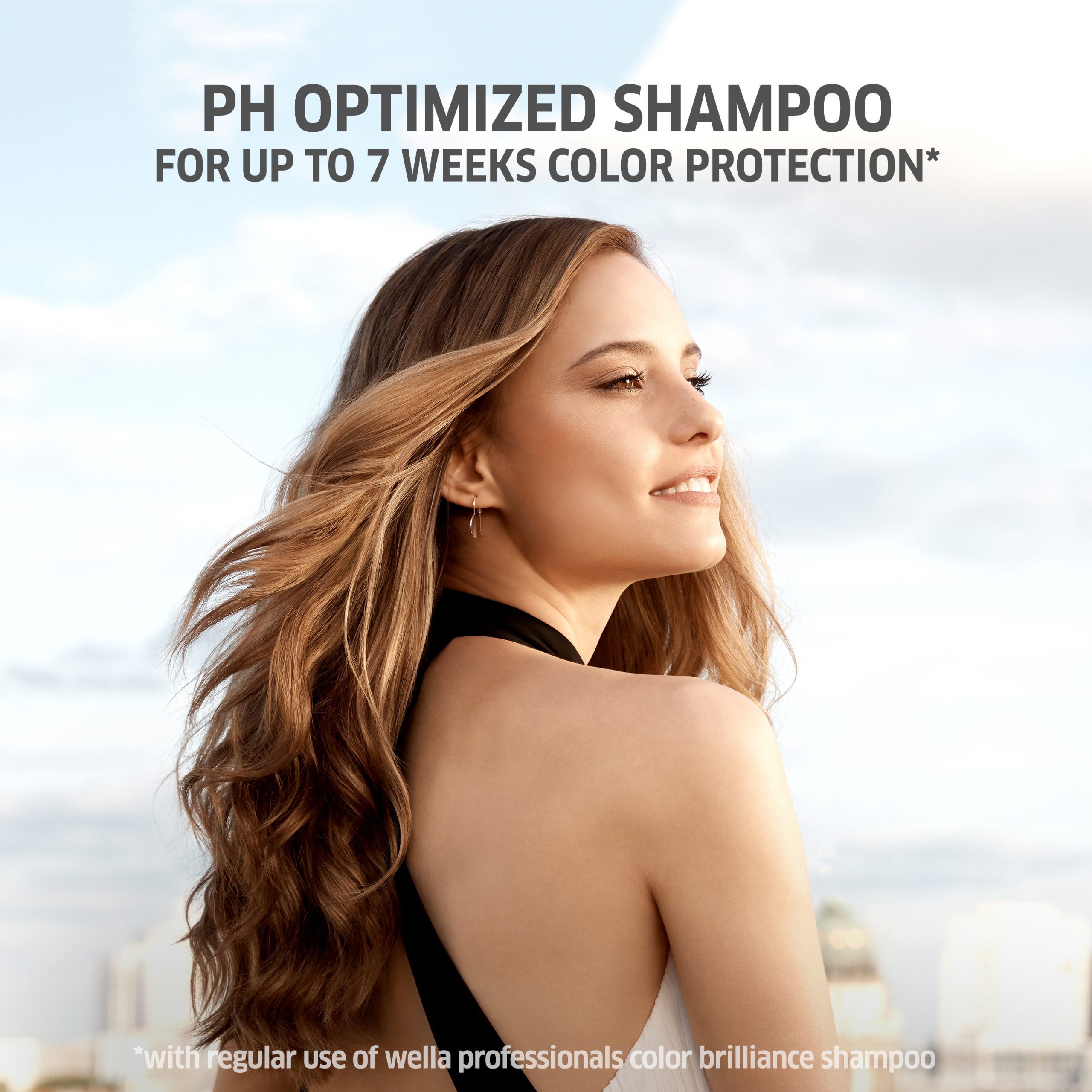 Frau mit langen, welligen Haaren. Text: PH OPTIMIZED SHAMPOO FOR UP TO 7 WEEKS COLOR PROTECTION.